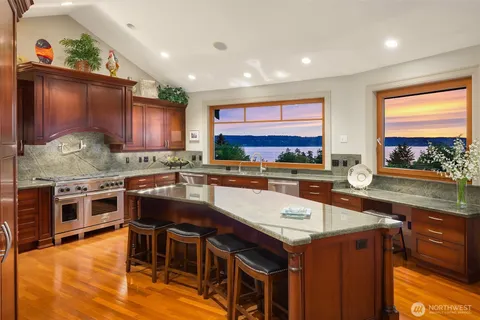 a kitchen with stainless steel appliances granite countertop wooden cabinets counter space and a large window