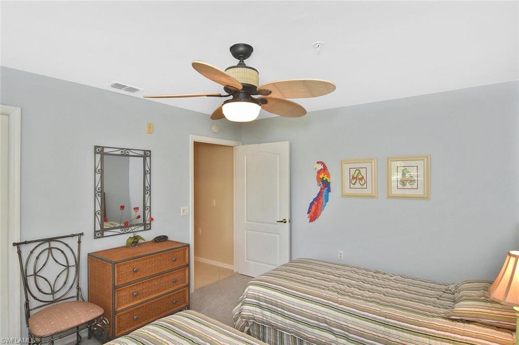 3870 Sawgrass Way, Unit 2521 Naples, FL 34112 - Photo 15 of 46 a bedroom with a bed and a chandelier
