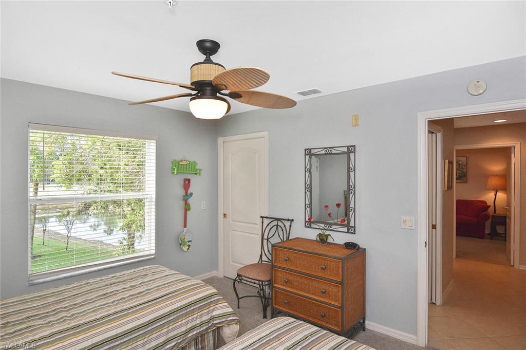 3870 Sawgrass Way, Unit 2521 Naples, FL 34112 - Photo 16 of 46 a bedroom with a bed and a chandelier