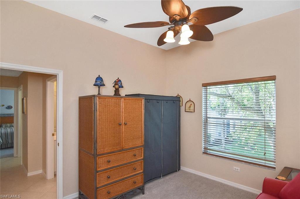 3870 Sawgrass Way, Unit 2521 Naples, FL 34112 - Photo 19 of 46 a view of a livingroom with a cabinet and a ceiling fan