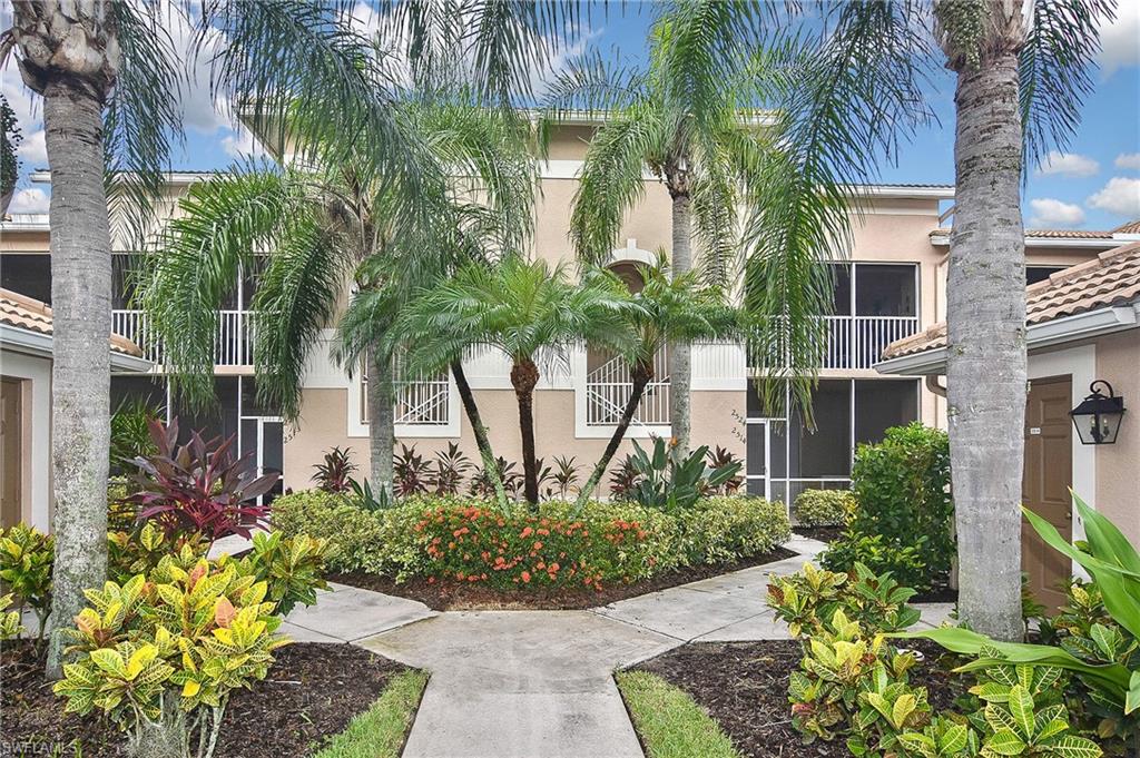 3870 Sawgrass Way, Unit 2521 Naples, FL 34112 - Photo 2 of 46 a front view of a multi story residential apartment building with yard and green space