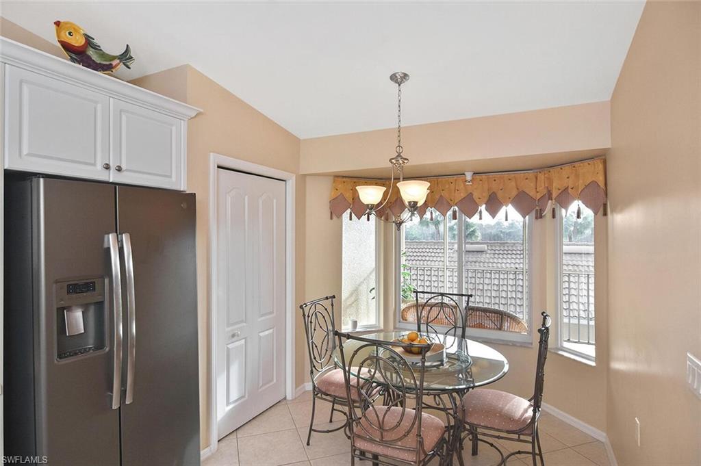 3870 Sawgrass Way, Unit 2521 Naples, FL 34112 - Photo 23 of 46 a kitchen with stainless steel appliances granite countertop a refrigerator and white cabinets