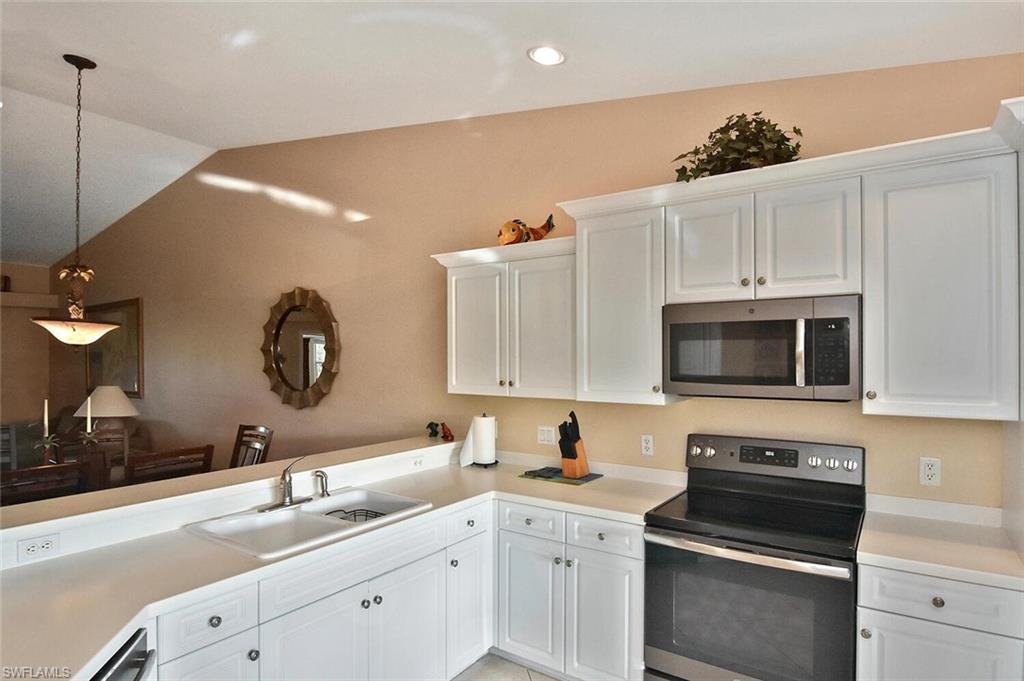 3870 Sawgrass Way, Unit 2521 Naples, FL 34112 - Photo 25 of 46 a kitchen with a sink stove and microwave