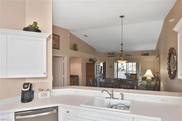 a kitchen with a sink and living room view