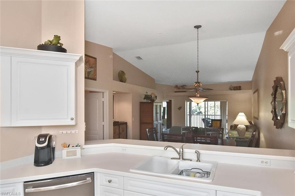 3870 Sawgrass Way, Unit 2521 Naples, FL 34112 - Photo 26 of 46 a kitchen with a sink and living room view