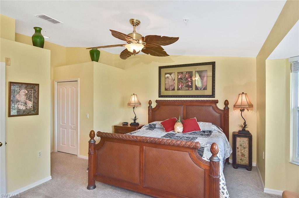 3870 Sawgrass Way, Unit 2521 Naples, FL 34112 - Photo 32 of 46 a bedroom with a bed and wooden floor
