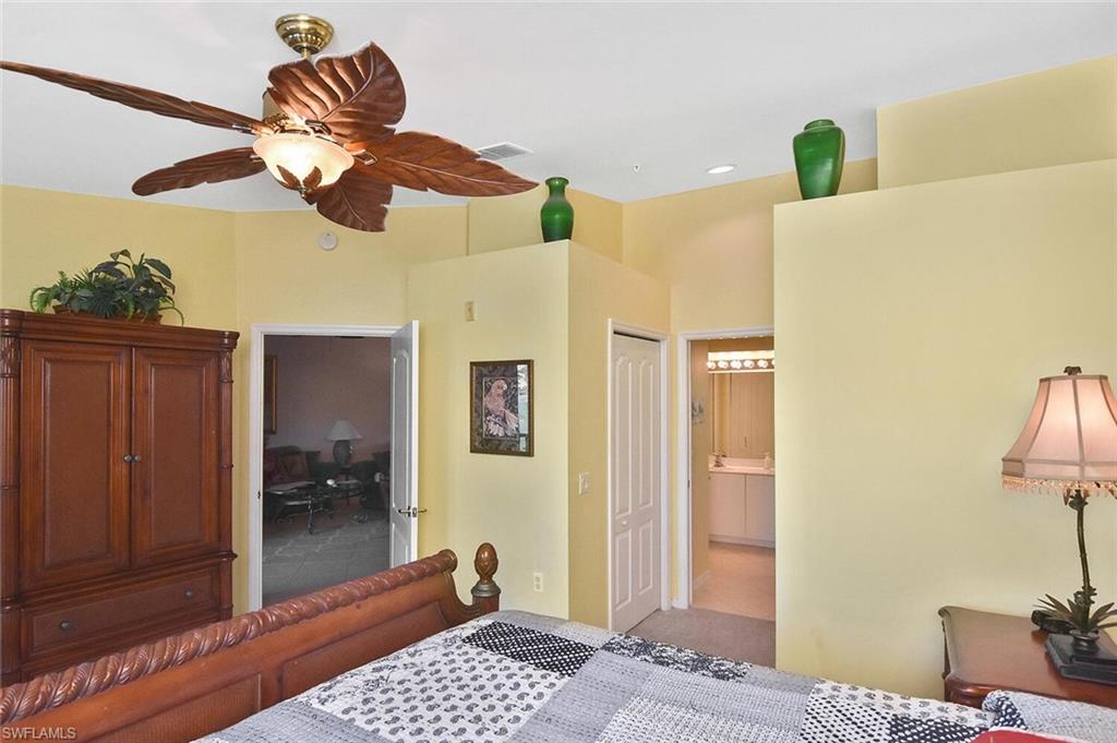 3870 Sawgrass Way, Unit 2521 Naples, FL 34112 - Photo 34 of 46 a bedroom with a bed and a chandelier