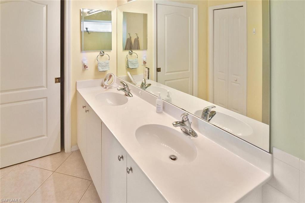 3870 Sawgrass Way, Unit 2521 Naples, FL 34112 - Photo 35 of 46 a bathroom with a double vanity sink and a mirror