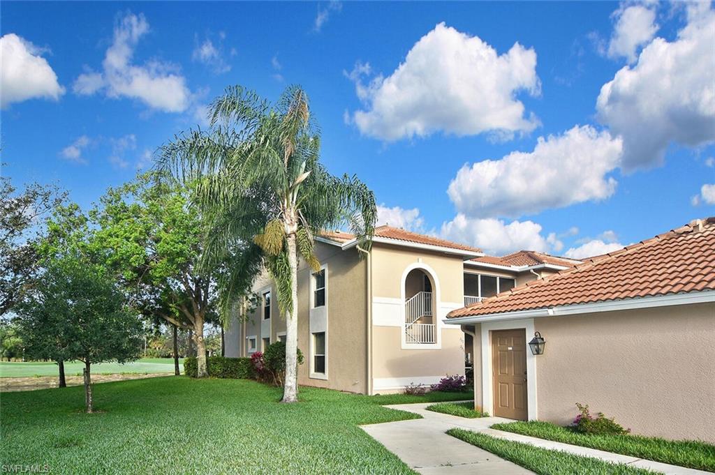 3870 Sawgrass Way, Unit 2521 Naples, FL 34112 - Photo 4 of 46 a view of white house with a big yard and large trees