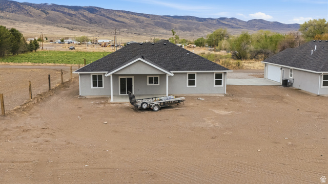 169 West 100 South Joseph, UT 84739 - Photo 2 of 35 View of front of house featuring a mountain view, stucco siding, a patio area, and dirt driveway