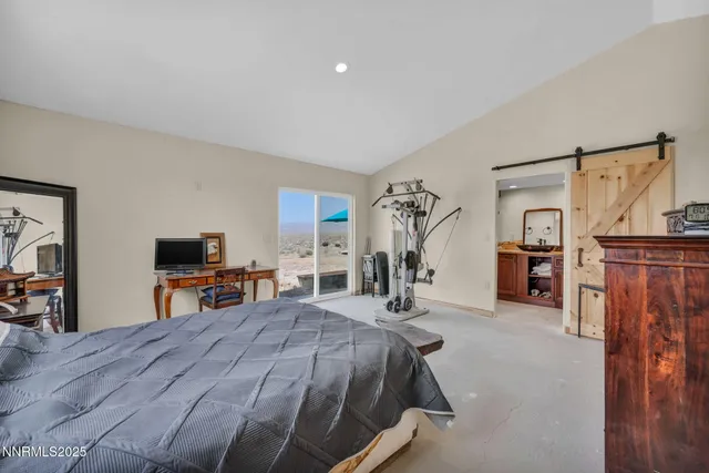 a bedroom with a bed and a flat tv screen on a dresser