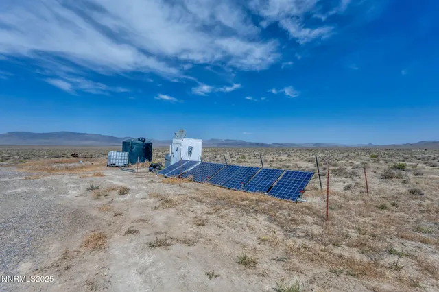 a view of a dry yard with wooden fence