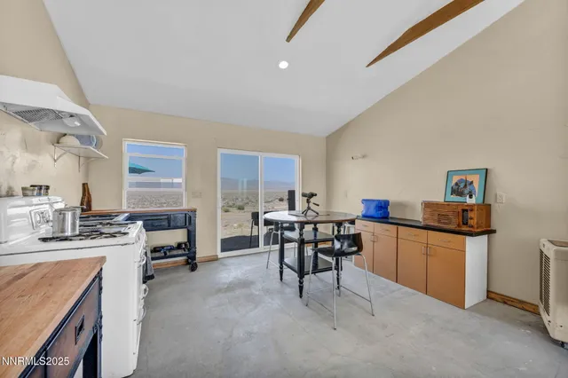 a kitchen with kitchen island a dining table chairs stainless steel appliances and cabinets