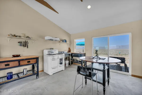 a view of a dining room with furniture and a kitchen