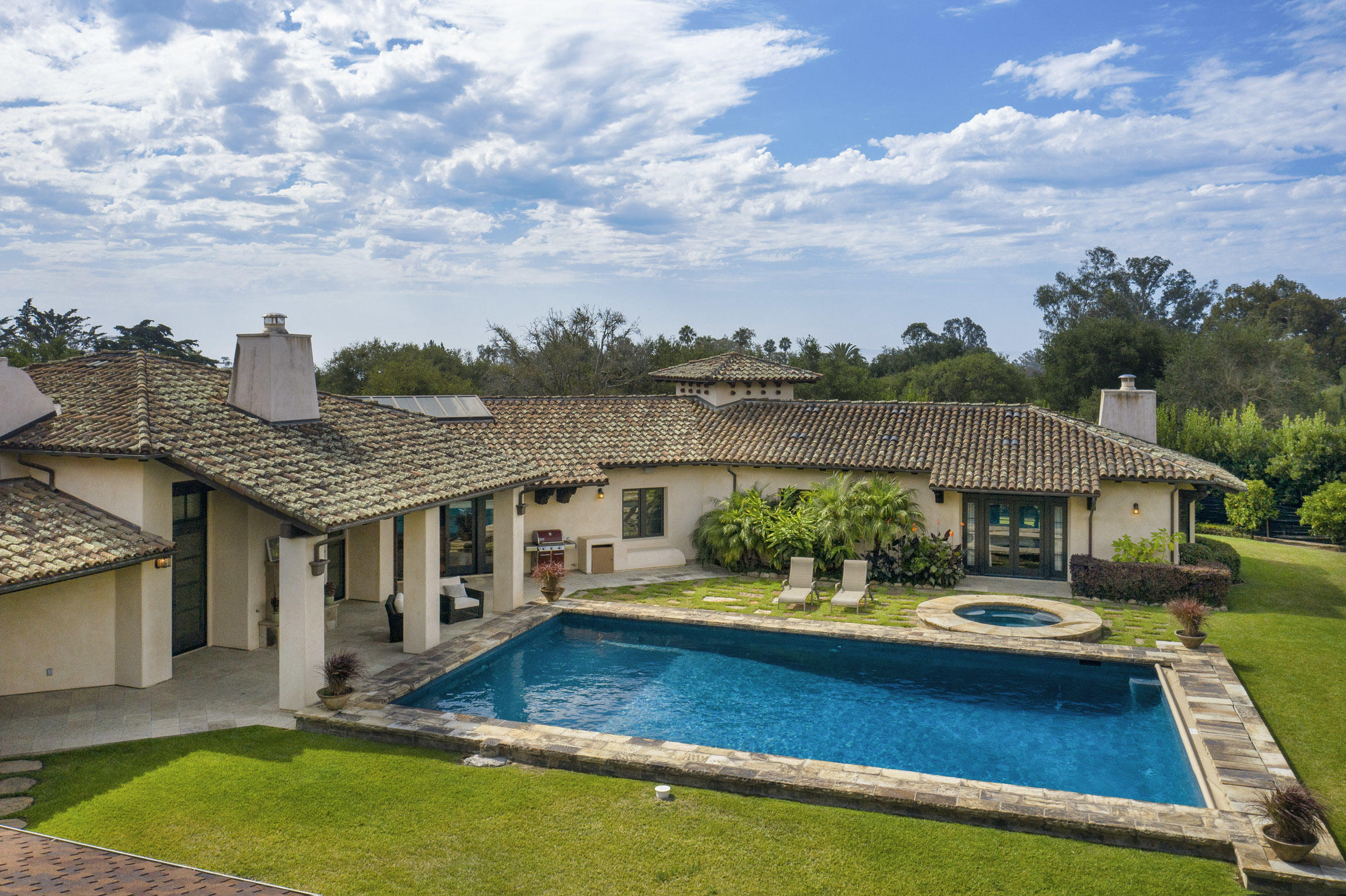 an aerial view of a house with swimming pool and lake view