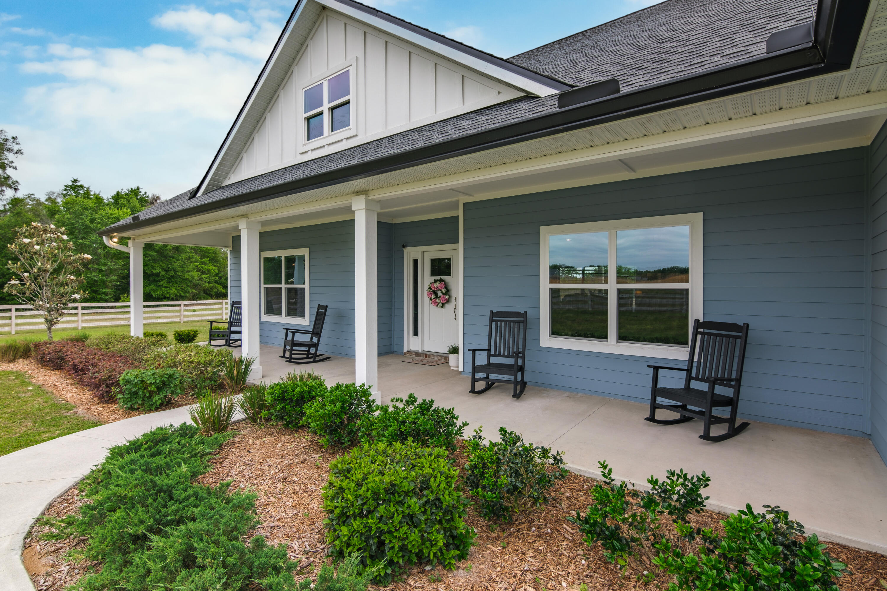 10172 98th Street, Unit 2 Live Oak, FL 32060 - Photo 2 of 37 a front view of a house with a garden and sitting area