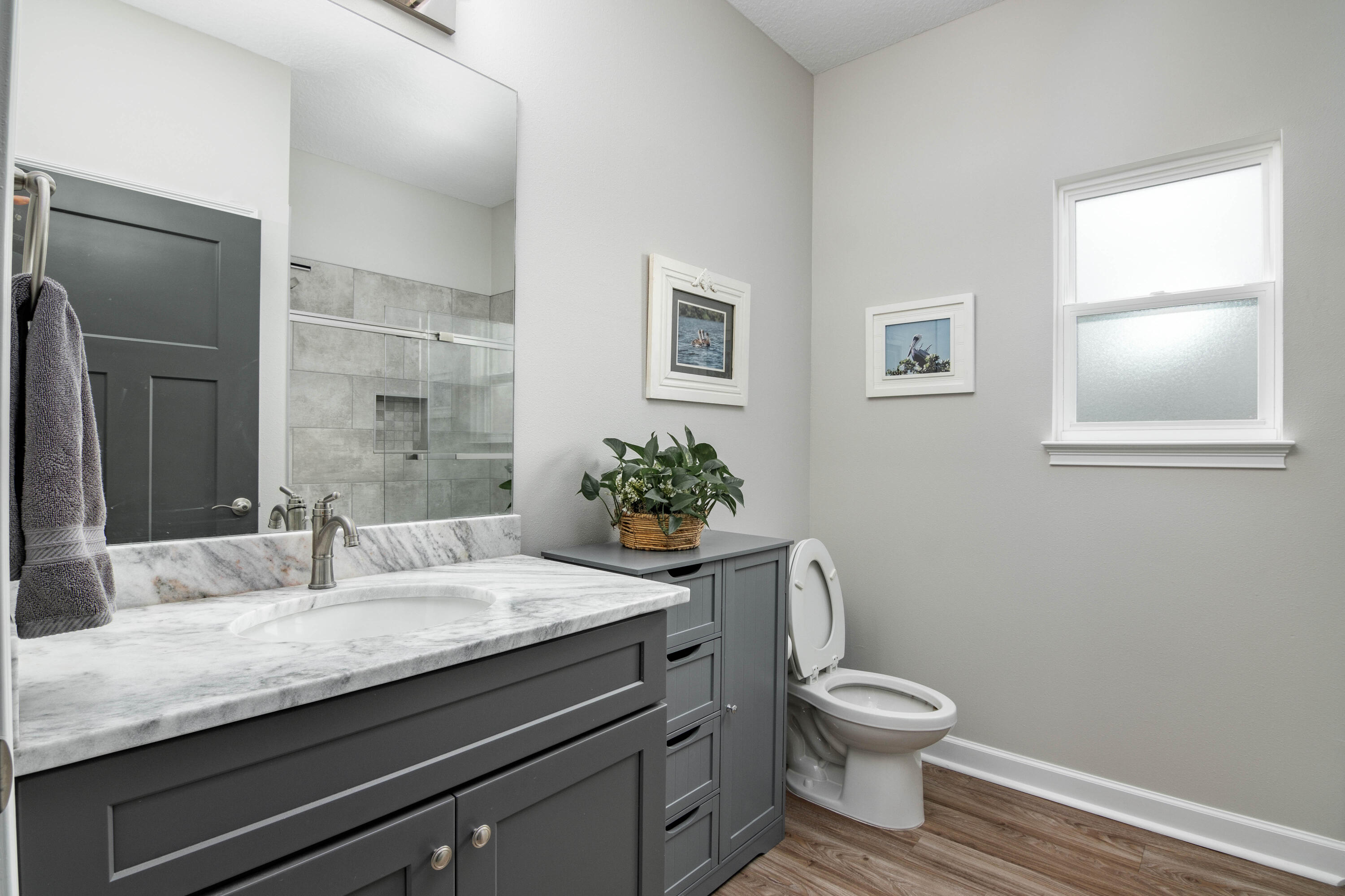 10172 98th Street, Unit 2 Live Oak, FL 32060 - Photo 32 of 37 a bathroom with a granite countertop toilet a sink and a mirror