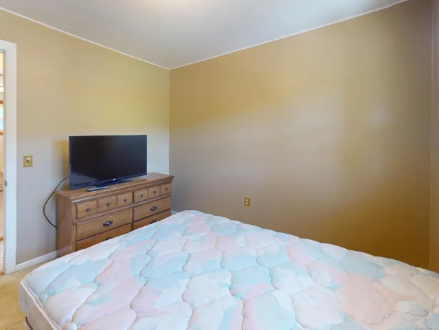 a bedroom with a bed and flat screen tv
