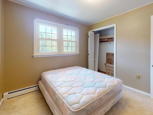 a bed sitting in a bedroom next to a window