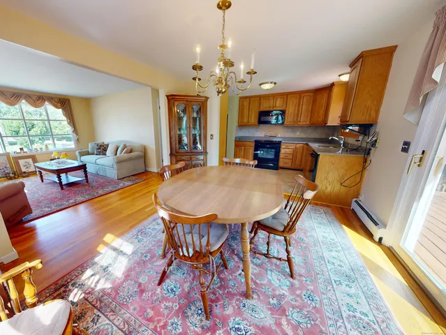 a view of a dining room with furniture a chandelier and wooden floor
