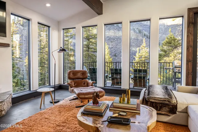 a living room with furniture and floor to ceiling windows