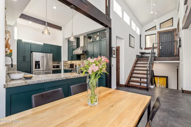 a kitchen with stainless steel appliances kitchen island granite countertop a dining table chairs and granite counter tops