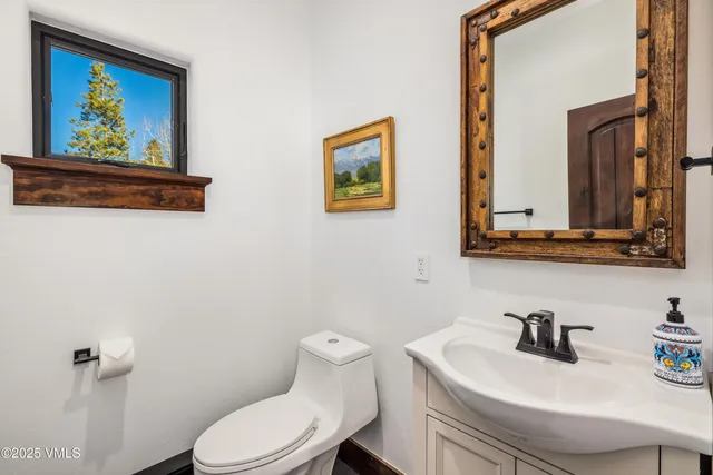 a bathroom with a toilet a sink and mirror