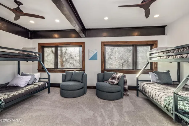 a living room with furniture a ceiling fan and a large window