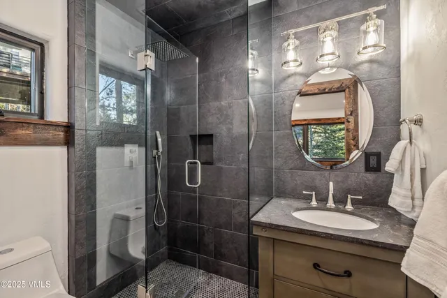 a bathroom with a sink a toilet and shower