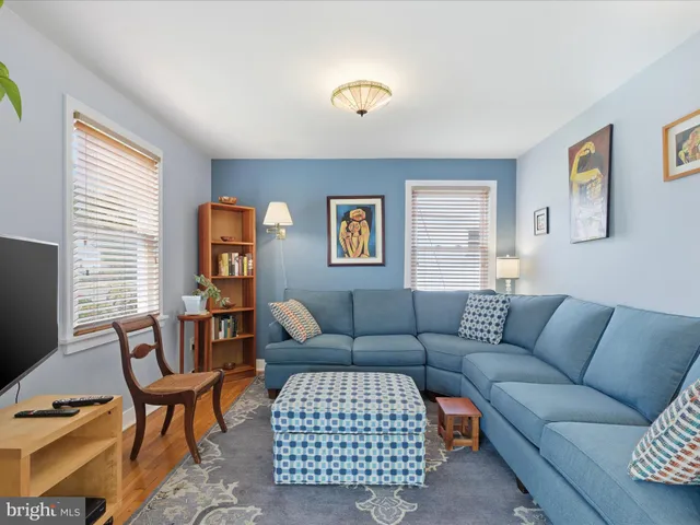 a living room with furniture a flat screen tv and a window