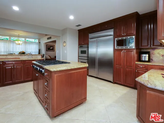 a kitchen with stainless steel appliances granite countertop a stove a refrigerator and a sink