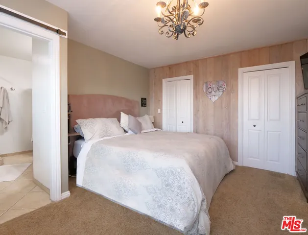 a bedroom with a bed and a chandelier