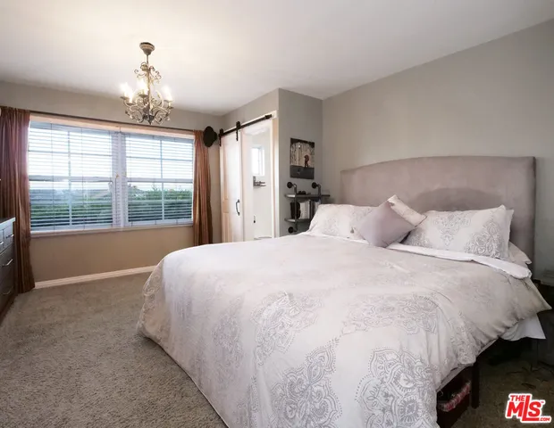 a large bed sitting in a bedroom next to a window