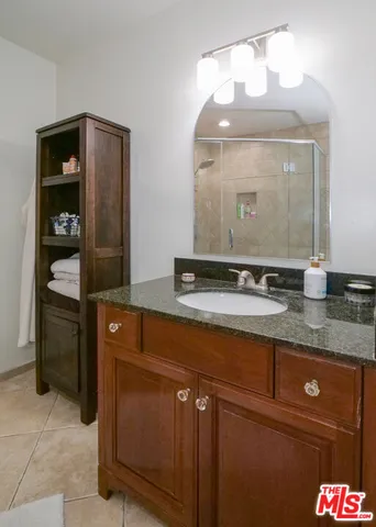a bathroom with a granite countertop sink and a mirror