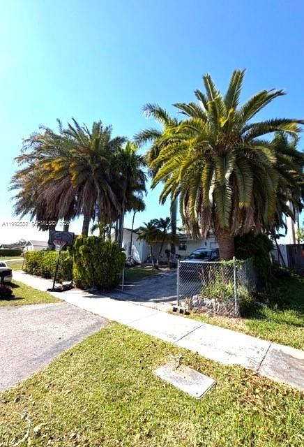 13041 Southwest 260th Terrace Homestead, FL 33032 - Photo 11 of 46 a view of a swimming pool with a lawn chair and palm trees