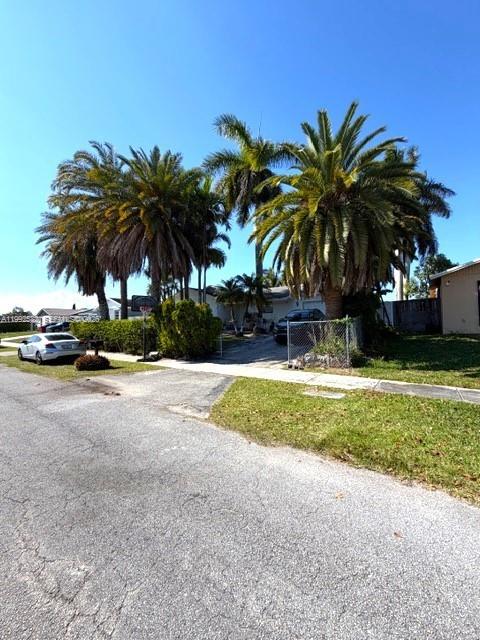 13041 Southwest 260th Terrace Homestead, FL 33032 - Photo 2 of 46 a palm tree sitting in front of a house with a big yard