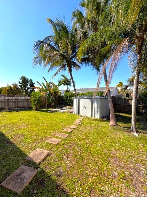 13041 Southwest 260th Terrace Homestead, FL 33032 - Photo 22 of 46 a view of a swimming pool with a lawn chairs under an umbrella