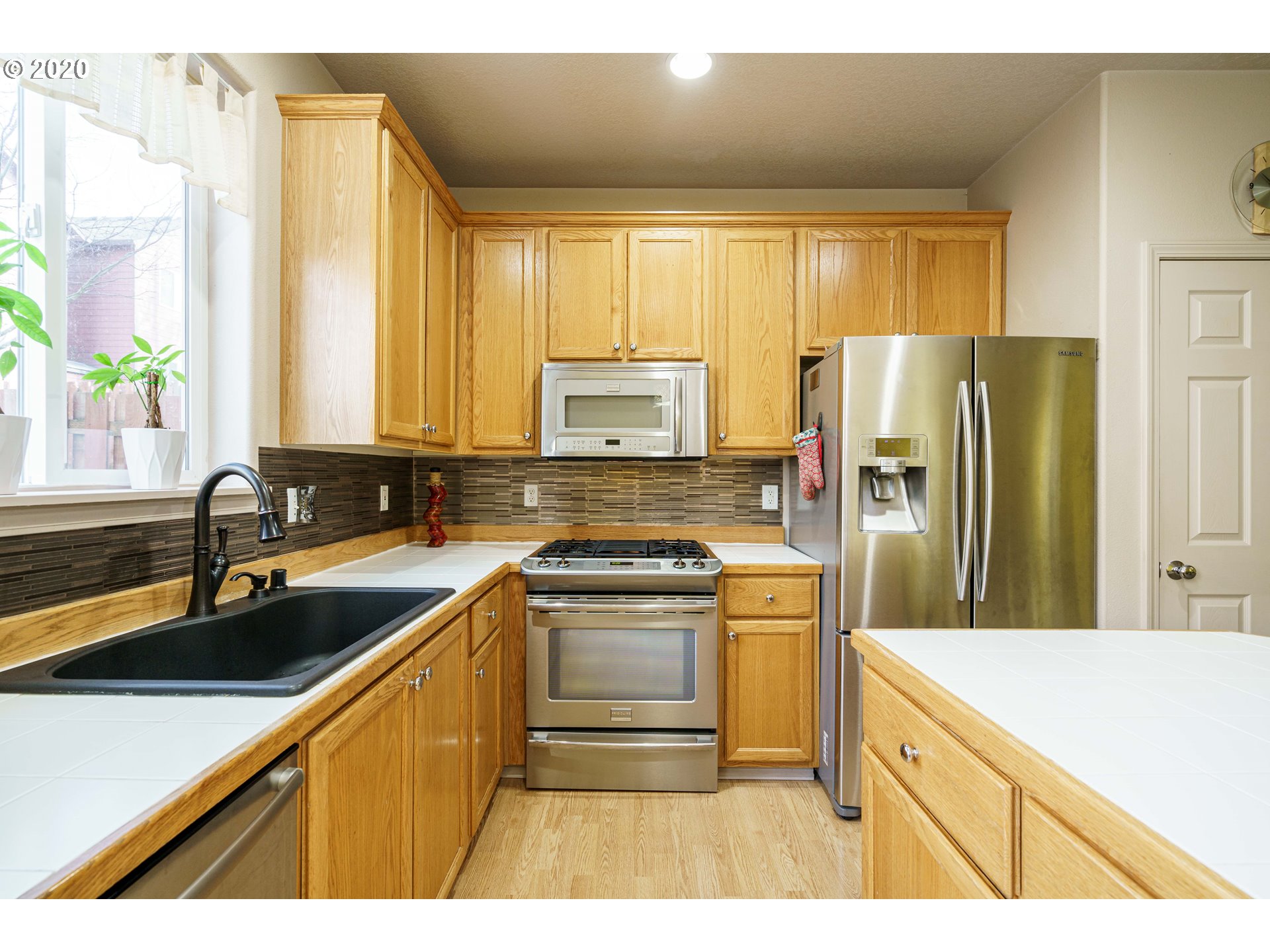 5843 Southeast 16th Loop Gresham, OR 97080 - Photo 11 of 30 a kitchen with a sink stove and refrigerator