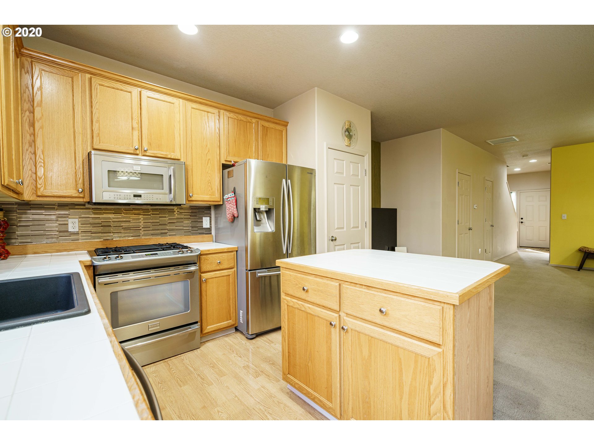 5843 Southeast 16th Loop Gresham, OR 97080 - Photo 12 of 30 a kitchen with refrigerator cabinets and wooden floor
