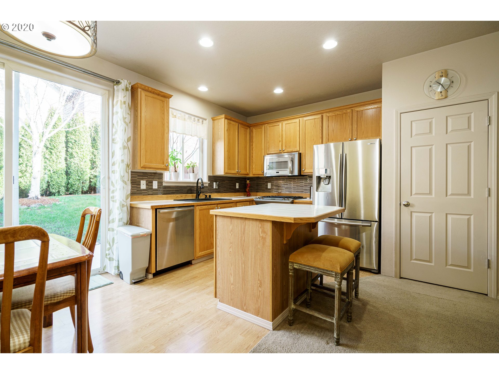 5843 Southeast 16th Loop Gresham, OR 97080 - Photo 13 of 30 a kitchen with a table chairs refrigerator and cabinets