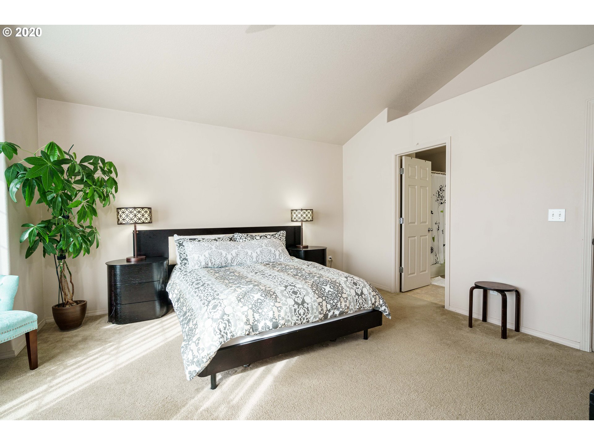5843 Southeast 16th Loop Gresham, OR 97080 - Photo 15 of 30 a bedroom with a bed table flowerpot and a potted plant