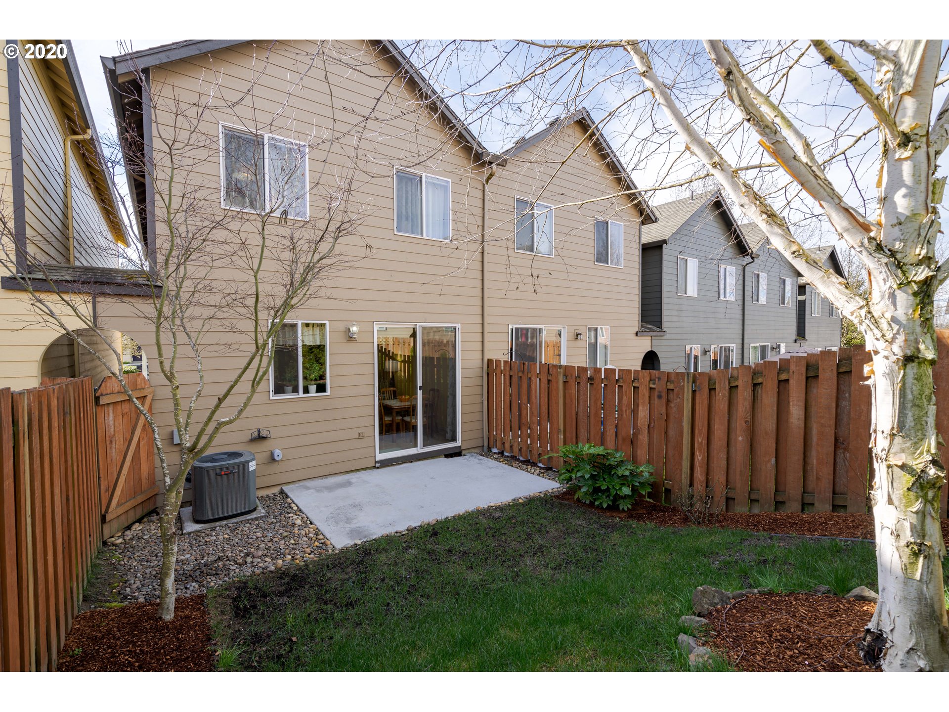5843 Southeast 16th Loop Gresham, OR 97080 - Photo 28 of 30 a view of a house with wooden fence and a large tree