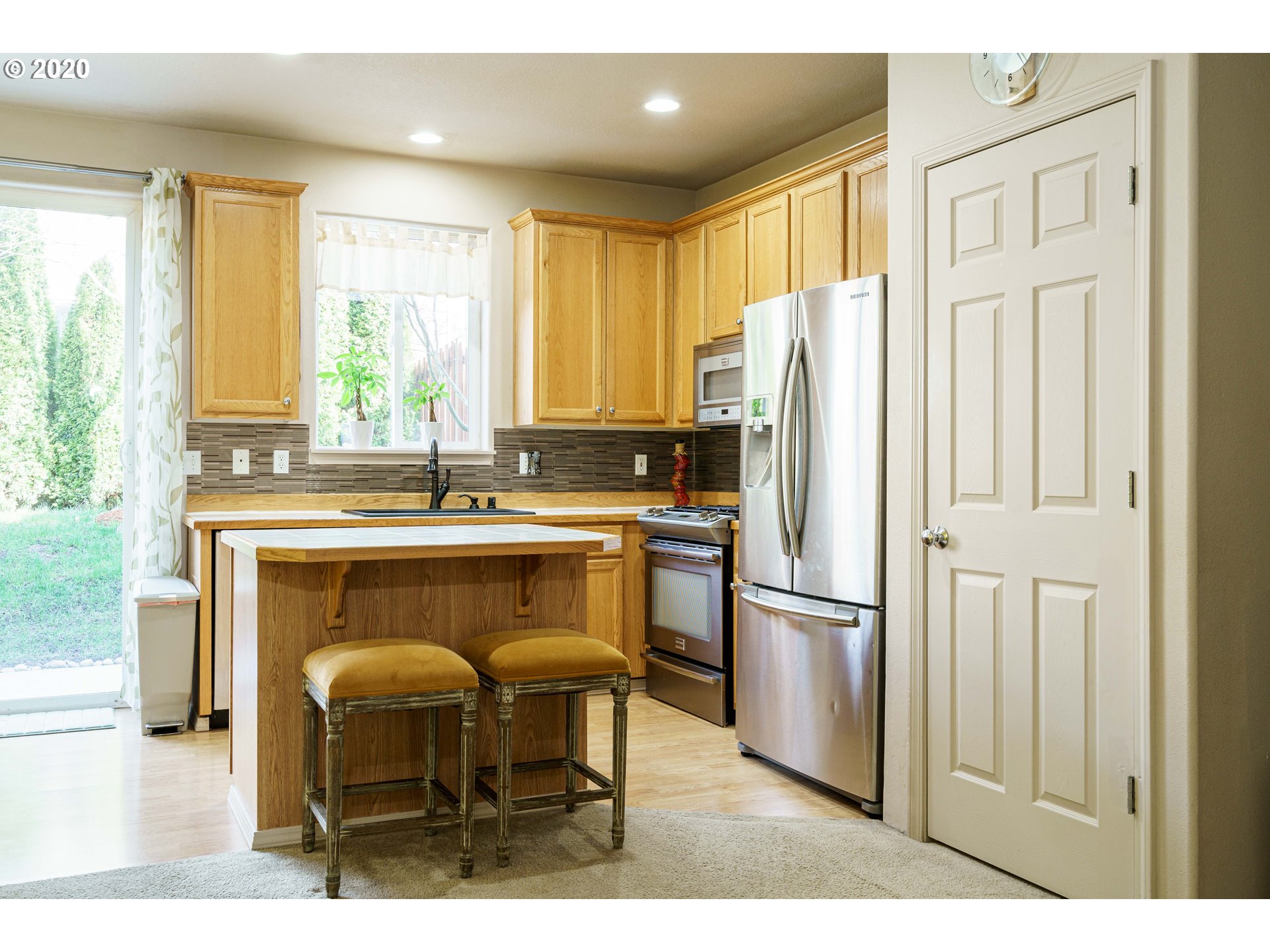 5843 Southeast 16th Loop Gresham, OR 97080 - Photo 9 of 30 a kitchen with stainless steel appliances granite countertop a refrigerator a stove a sink dishwasher and wooden cabinets with wooden floor