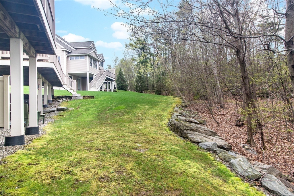 31 Sunset Ridge Lane, Unit 31 Bolton, MA 01740 - Photo 15 of 25 a yellow building in the middle of a yard