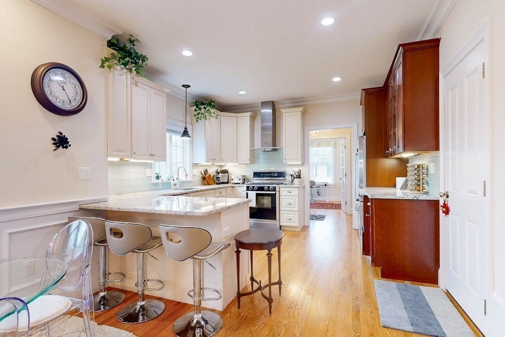31 Sunset Ridge Lane, Unit 31 Bolton, MA 01740 - Photo 3 of 25 a kitchen with granite countertop a table chairs stove and cabinets