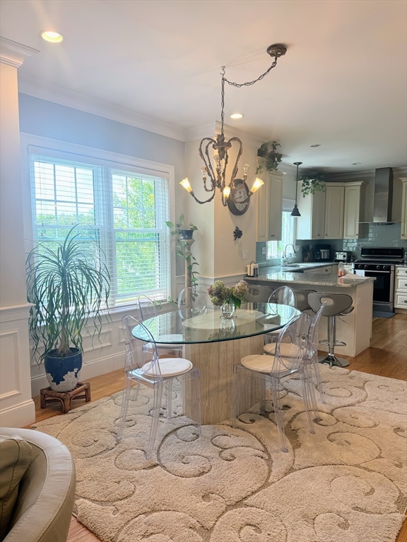 31 Sunset Ridge Lane, Unit 31 Bolton, MA 01740 - Photo 5 of 25 a living room with couches a chandelier and a dining table with garden view