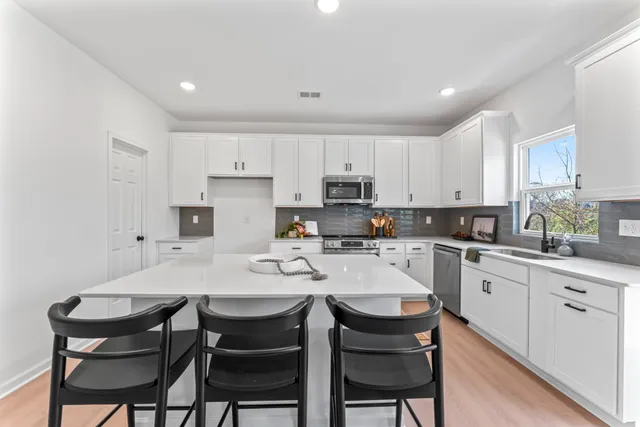 a kitchen with stainless steel appliances kitchen island granite countertop a sink and cabinets