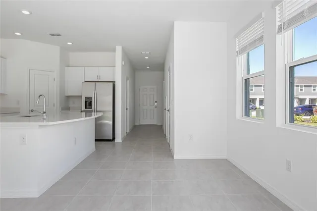 a large white kitchen with a sink and refrigerator