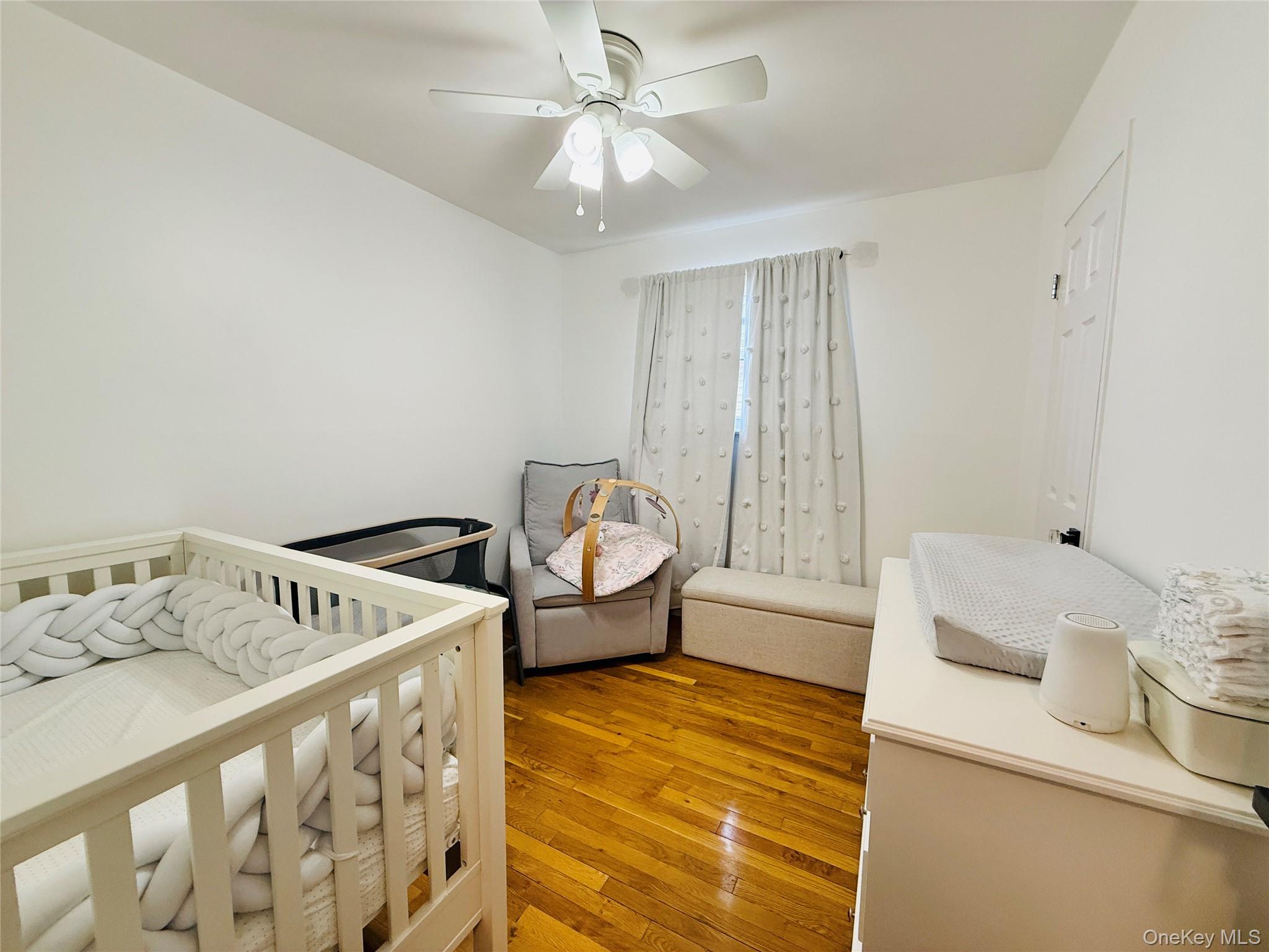 1663 Waring Avenue Bronx, NY 10469 - Photo 12 of 34 a bedroom with a bed and wooden floor