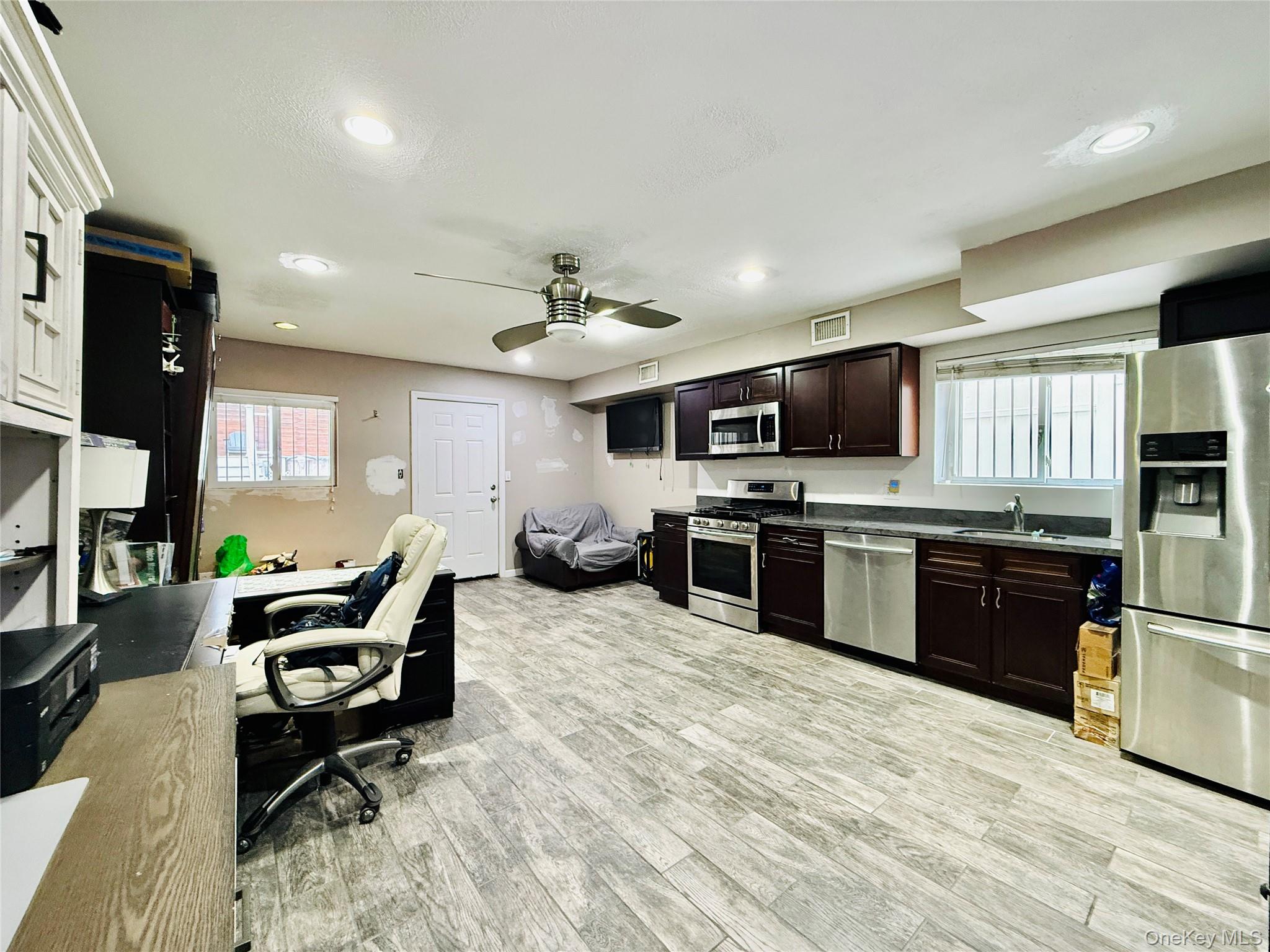 1663 Waring Avenue Bronx, NY 10469 - Photo 25 of 34 a kitchen with stainless steel appliances kitchen island granite countertop a stove top oven a sink dishwasher a dining table and chairs with wooden floor